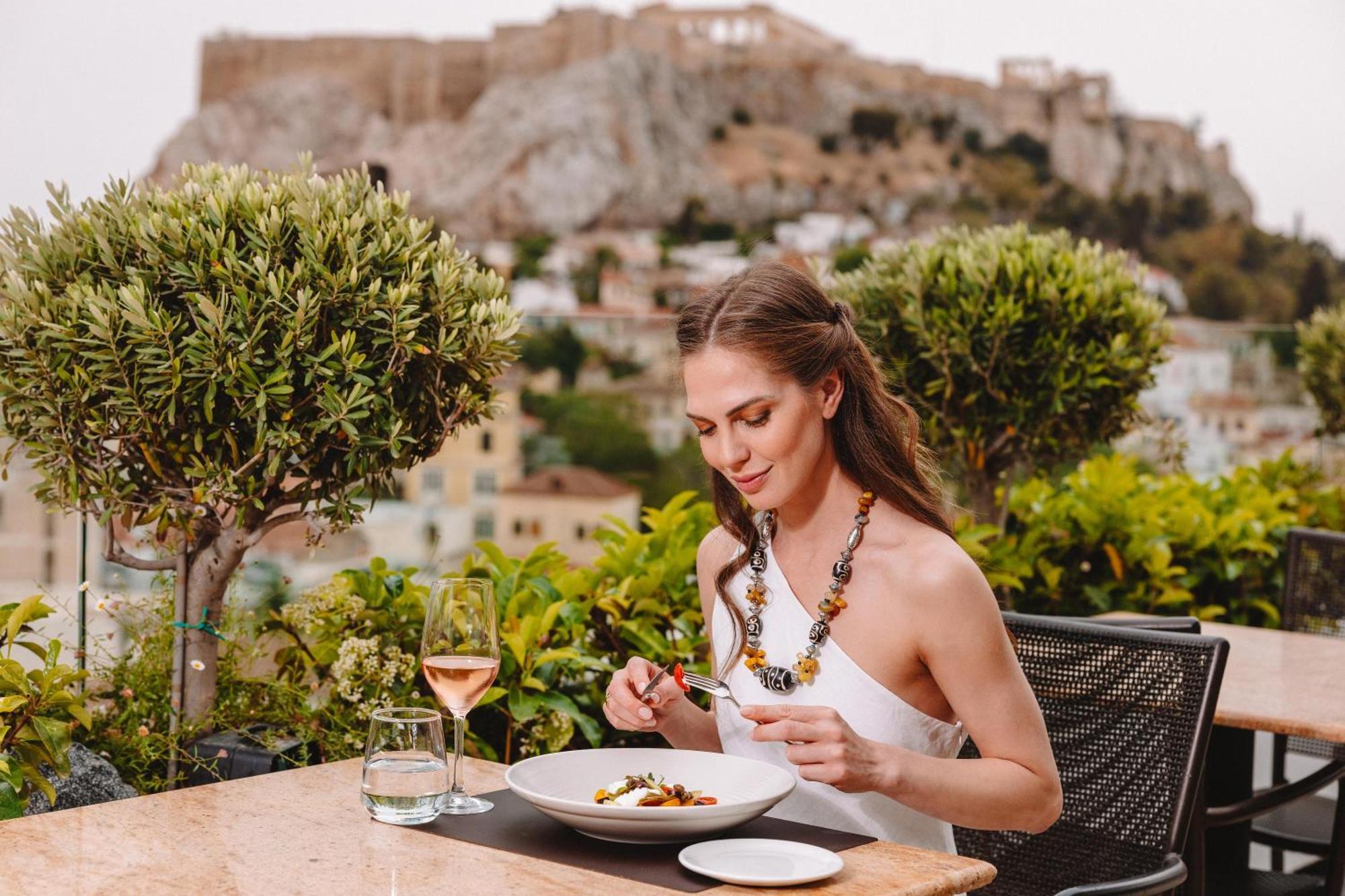 Electra Palace Athens Hotel Buitenkant foto A woman eating at a restaurant